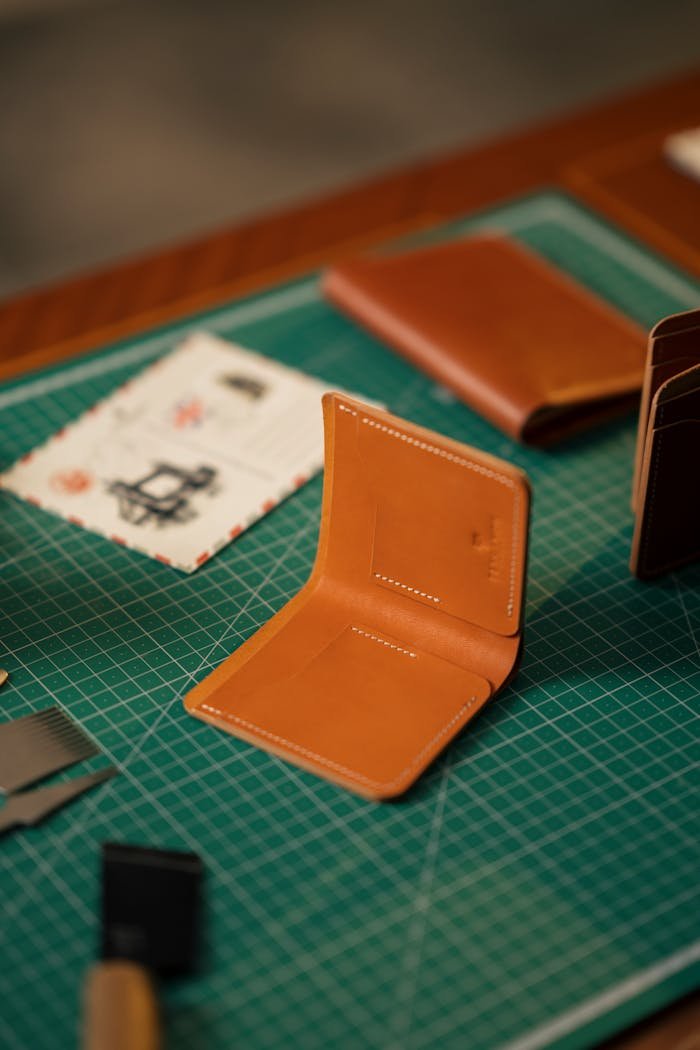 Crafting Captivating Headlines: Your awesome post title goes here Close-up of handcrafted leather wallets on a green cutting mat, showcasing craftsmanship and design.
