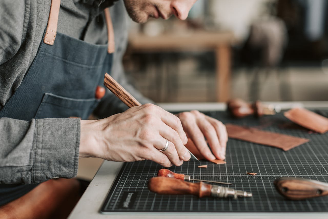 Mastering the First Impression: Your intriguing post title goes here Close-up of an artisan skillfully crafting leather goods by hand in a workshop environment.
