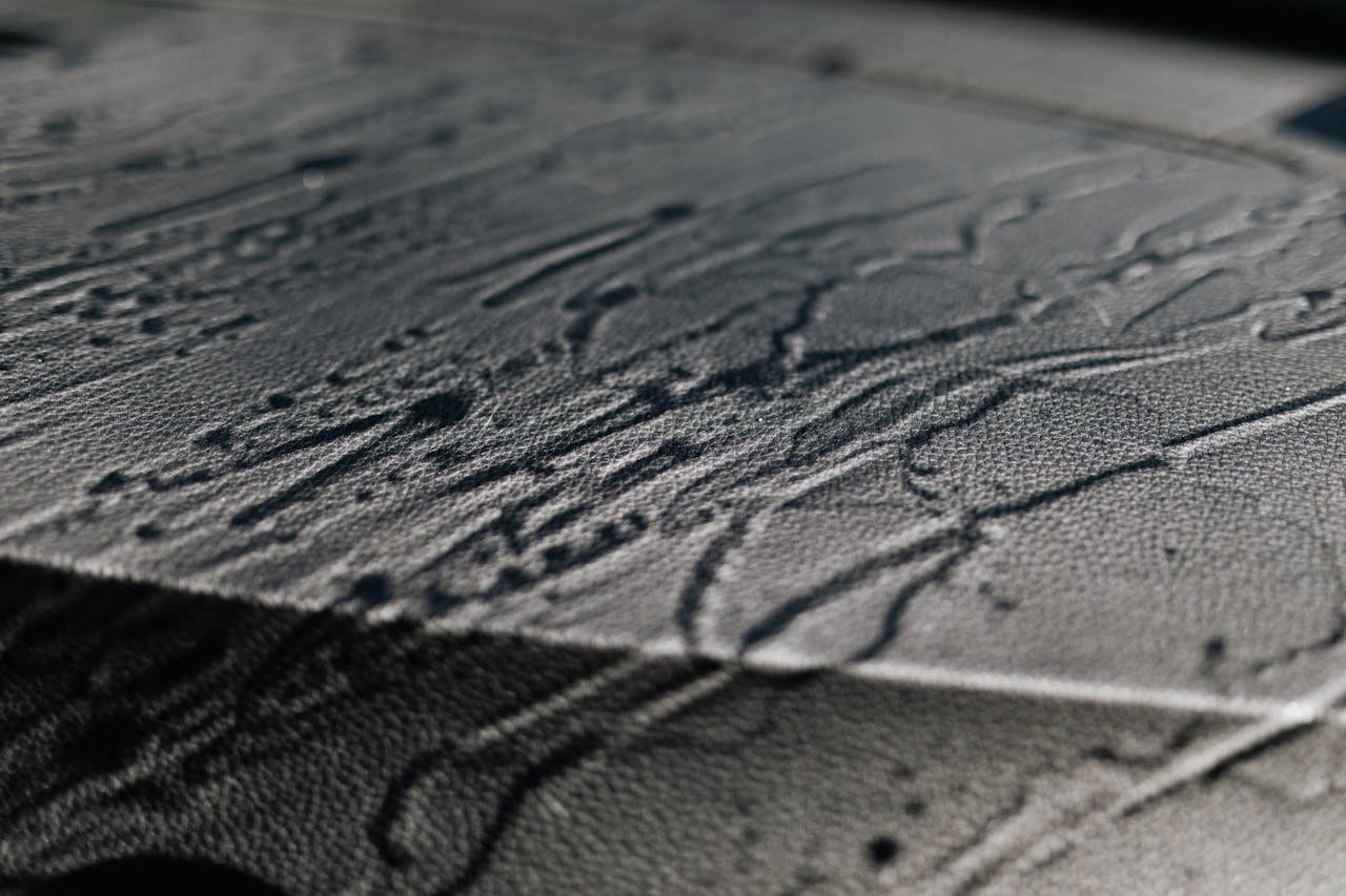 Services Extreme close-up of textured leather with shadows and intricate patterns.